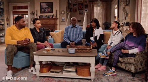 A Group Of People Are Sitting On A Couch In A Living Room GIF