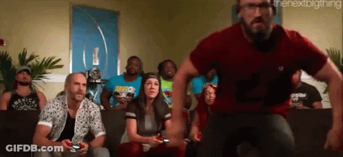 A Group Of People Are Sitting On A Couch Playing A Video Game While A Man In A Red Shirt Is Running Towards Them GIF