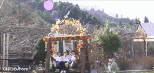 People Sitting On Wooden Swing In Park GIF