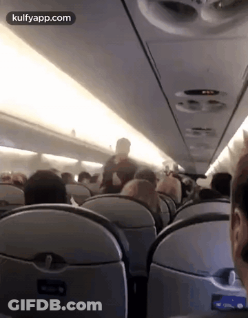 A Group Of People Are Sitting On An Airplane And The Website Kulfyapp.com Is Displayed In The Corner GIF