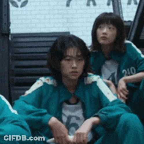 A Group Of People Are Sitting On The Floor In A Room . GIF