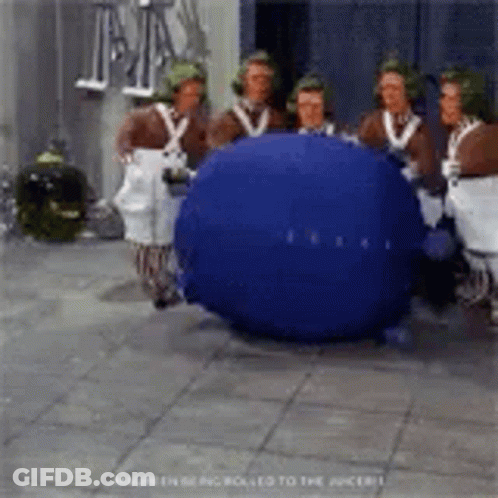 A Group Of People Are Standing Around A Blueberry . GIF