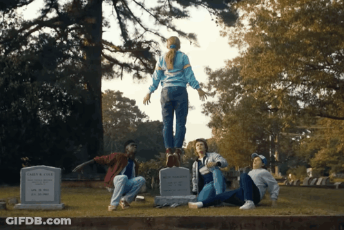 A Group Of People Are Standing Around A Grave That Says John R. Cole On It GIF