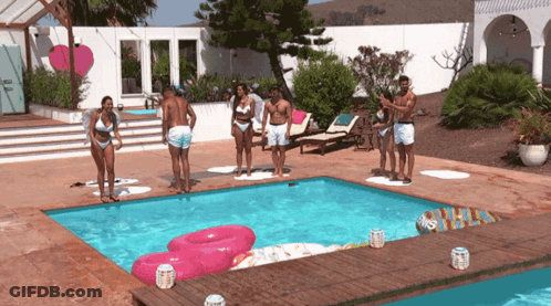 A Group Of People Are Standing Around A Pool GIF