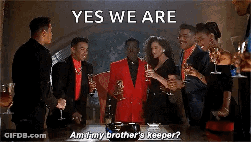 A Group Of People Are Standing Around A Table Holding Champagne Glasses And A Man In A Red Suit Is Saying Yes We Are . GIF