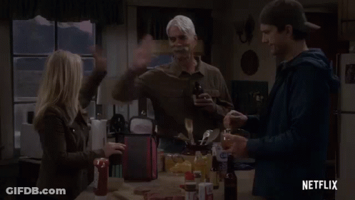A Group Of People Are Standing Around A Table In A Kitchen With A Netflix Logo In The Corner . GIF