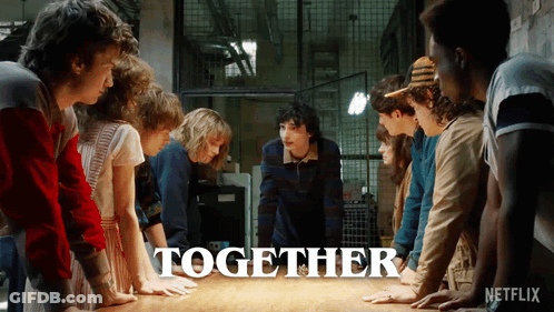 A Group Of People Are Standing Around A Table With The Word Together Written On It GIF