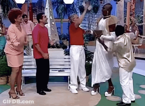 A Group Of People Are Standing Around A Woman In A Dress GIF