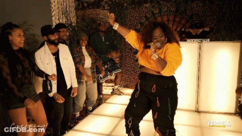 A Group Of People Are Standing Around A Woman On A Dance Floor With Creeping Written On The Bottom GIF