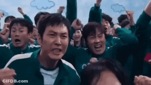 A Group Of People Are Standing In A Crowd With Their Arms In The Air And Making Funny Faces . GIF