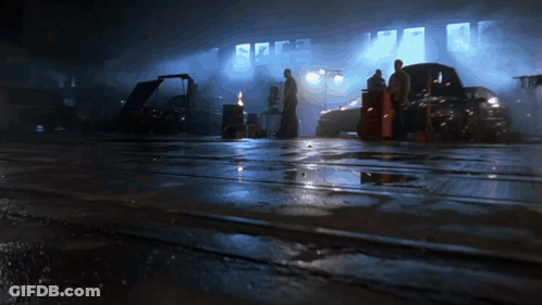 A Group Of People Are Standing In A Dark Garage GIF