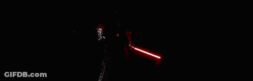 A Group Of People Are Standing In A Dark Room Holding Red Lightsabers . GIF