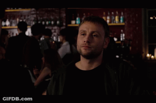 A Group Of People Are Standing In A Dark Room With A Man Looking Up GIF