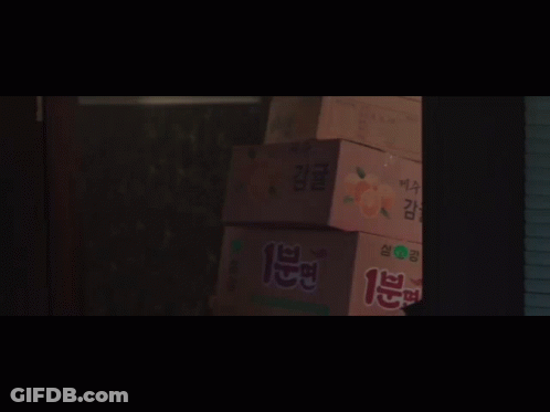 A Group Of People Are Standing In A Dark Room With A Sign That Says ' I 'M Sorry ' On It GIF