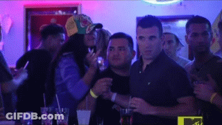 A Group Of People Are Standing In A Dark Room With Purple Lights . GIF