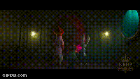 A Group Of People Are Standing In A Dark Room With Purple Lights . GIF