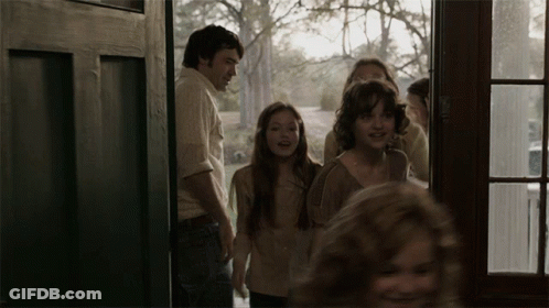 A Group Of People Are Standing In A Doorway Looking Out The Window GIF