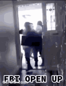 A Group Of People Are Standing In A Doorway With The Words `` Fbi Open Up '' Written On The Bottom . GIF