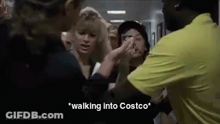 A Group Of People Are Standing In A Hallway Talking To Each Other . GIF