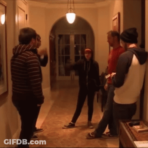 A Group Of People Are Standing In A Hallway GIF