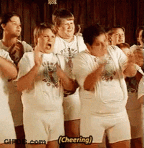 A Group Of People Are Standing In A Line And One Of Them Is Cheering . GIF