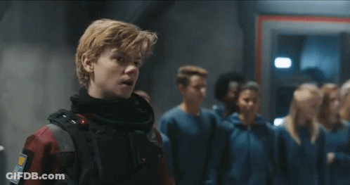 A Group Of People Are Standing In A Line In A Room . GIF