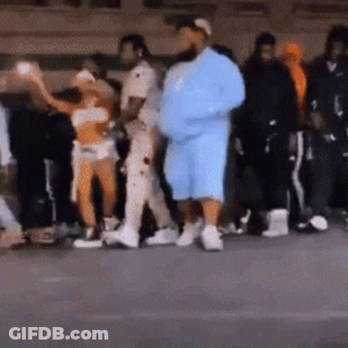A Group Of People Are Standing In A Line . GIF