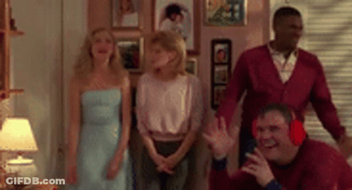 A Group Of People Are Standing In A Living Room . GIF