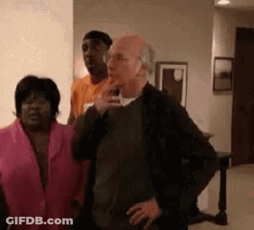 A Group Of People Are Standing In A Living Room . One Of The People Is Smoking A Cigarette . GIF
