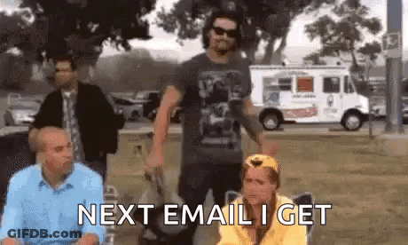 A Group Of People Are Standing In A Park And One Of Them Is Sitting In A Chair With The Words Next Email I Get . GIF