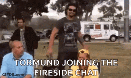A Group Of People Are Standing In A Park And Talking To Each Other . GIF
