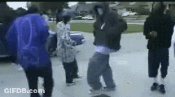 A Group Of People Are Standing In A Parking Lot Dancing . GIF