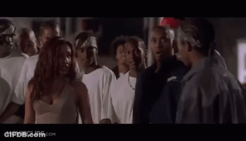 A Group Of People Are Standing In A Room And A Woman Is Standing In The Middle Of The Room . GIF