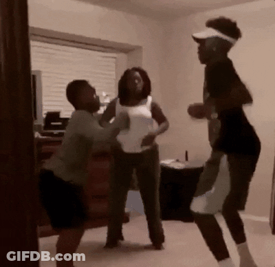 A Group Of People Are Standing In A Room And Fighting GIF