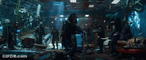 A Group Of People Are Standing In A Room . GIF