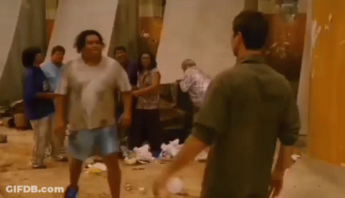 A Group Of People Are Standing In A Room With A Lot Of Trash . GIF