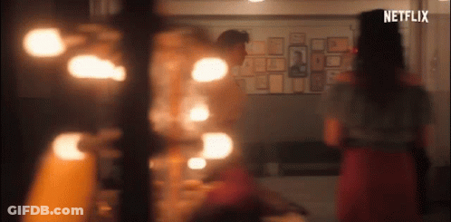 A Group Of People Are Standing In A Room With A Netflix Logo On The Bottom Of The Screen . GIF