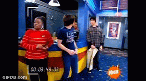 A Group Of People Are Standing In A Room With A Nick Logo On The Wall . GIF