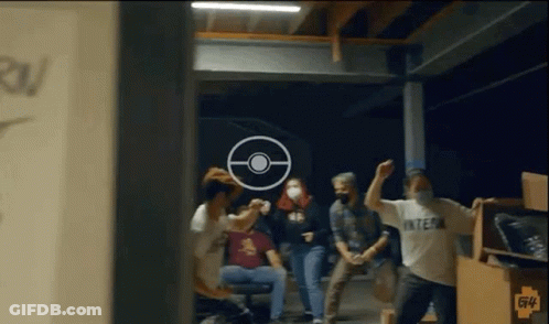 A Group Of People Are Standing In A Room With A Target In The Background . GIF
