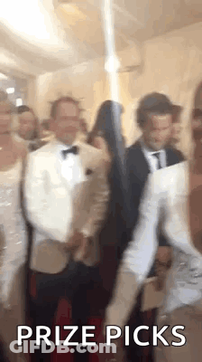 A Group Of People Are Standing In A Room With The Words `` Prize Picks '' Written On It . GIF