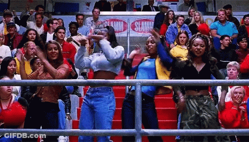 A Group Of People Are Standing In A Stadium Watching A Basketball Game And Dancing . GIF