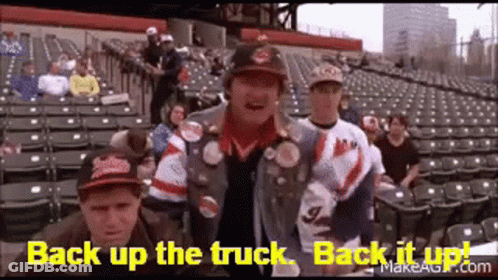 A Group Of People Are Standing In A Stadium With The Words `` Back Up The Truck , Back It Up '' Written On The Screen . GIF