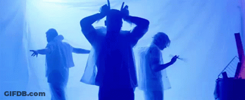 A Group Of People Are Standing In Front Of A Blue Background . GIF