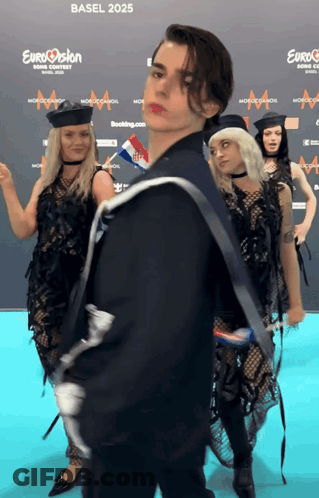 A Group Of People Are Standing In Front Of A Blue Carpet That Says Eurovision On It GIF