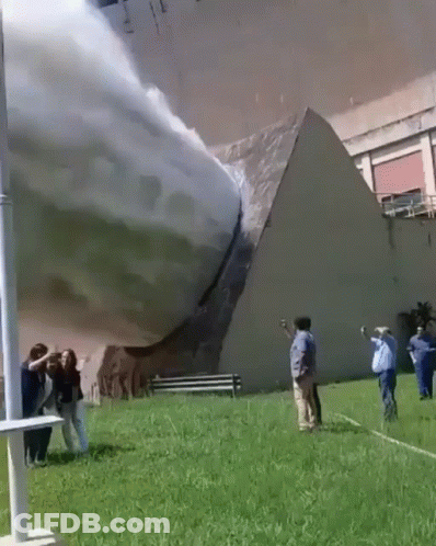 A Group Of People Are Standing In Front Of A Building That Has A Pyramid On It GIF