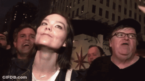 A Group Of People Are Standing In Front Of A Building That Says ' A & R ' On It GIF