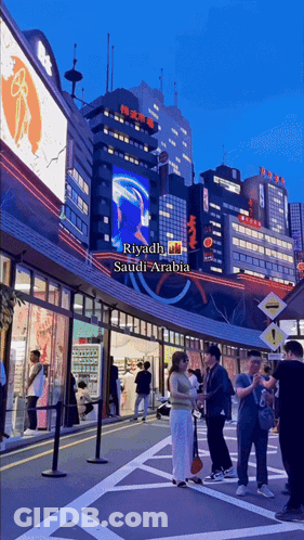 A Group Of People Are Standing In Front Of A Building That Says Riyadh On It GIF