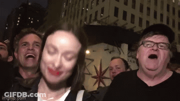 A Group Of People Are Standing In Front Of A Building With A Star On It . GIF
