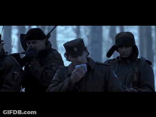 A Group Of People Are Standing In Front Of A Bus That Says ' Ambulance ' On The Side Of It GIF