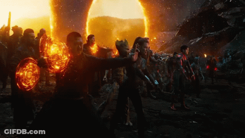 A Group Of People Are Standing In Front Of A Huge Fireball GIF